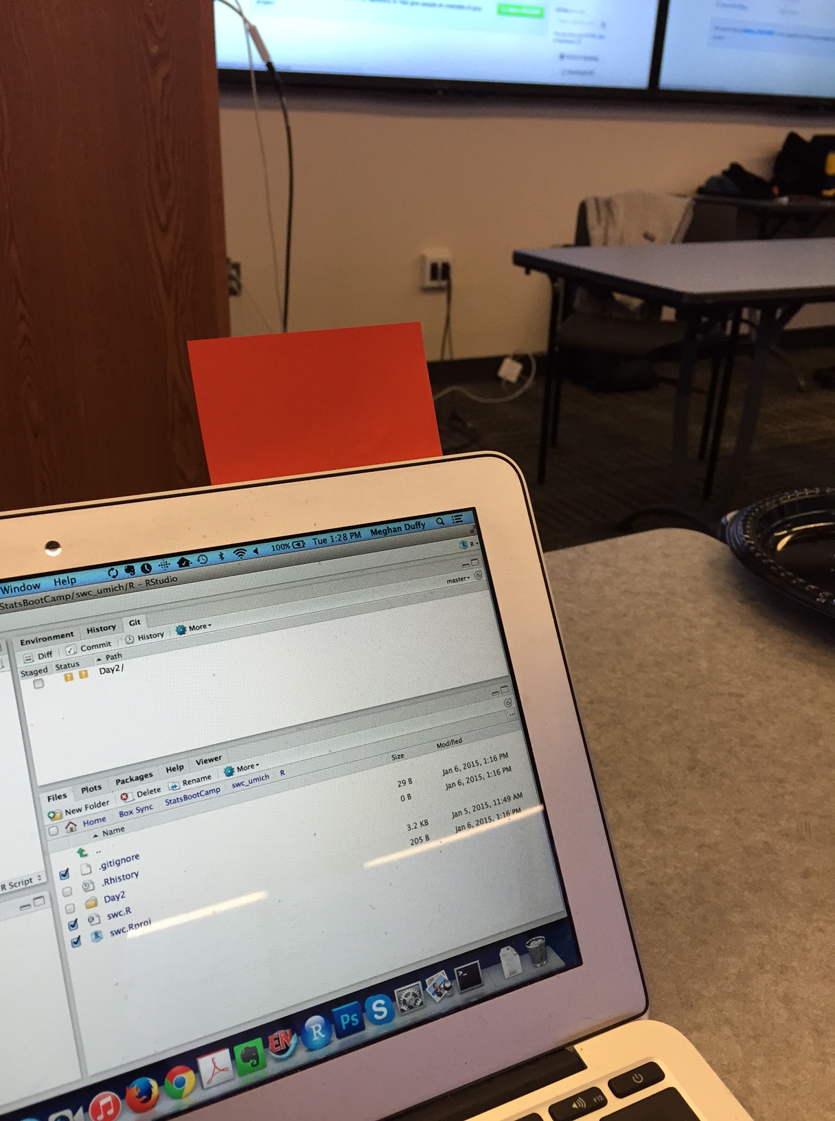 Picture of a laptop with a red sticky note stuck to the top.